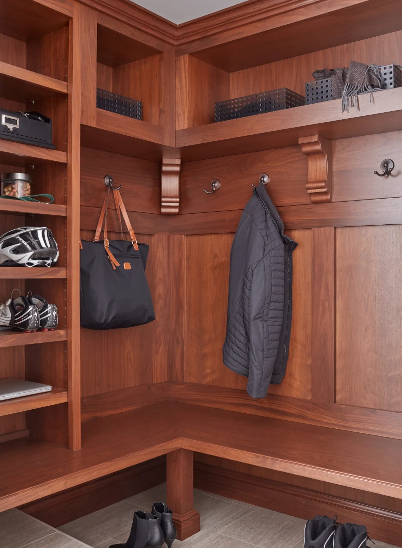 Warm wood mudroom bench with hooks and open storage